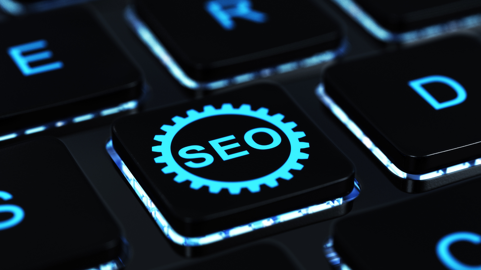 A close-up of a computer keyboard with a key labeled SEO inside a gear icon, illuminated with blue backlighting, representing Astoria Media Group's expertise in WordPress development and Abilene Texas marketing solutions.