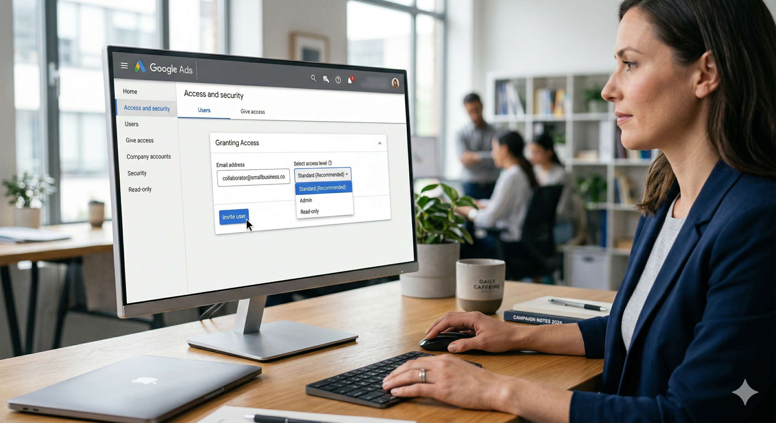 A professional setting showing a woman at a desk using a monitor to grant access to a Google Ads account. The screen displays the "Access and Security" menu with an invitation box for email and a dropdown to select access levels like Standard or Admin.